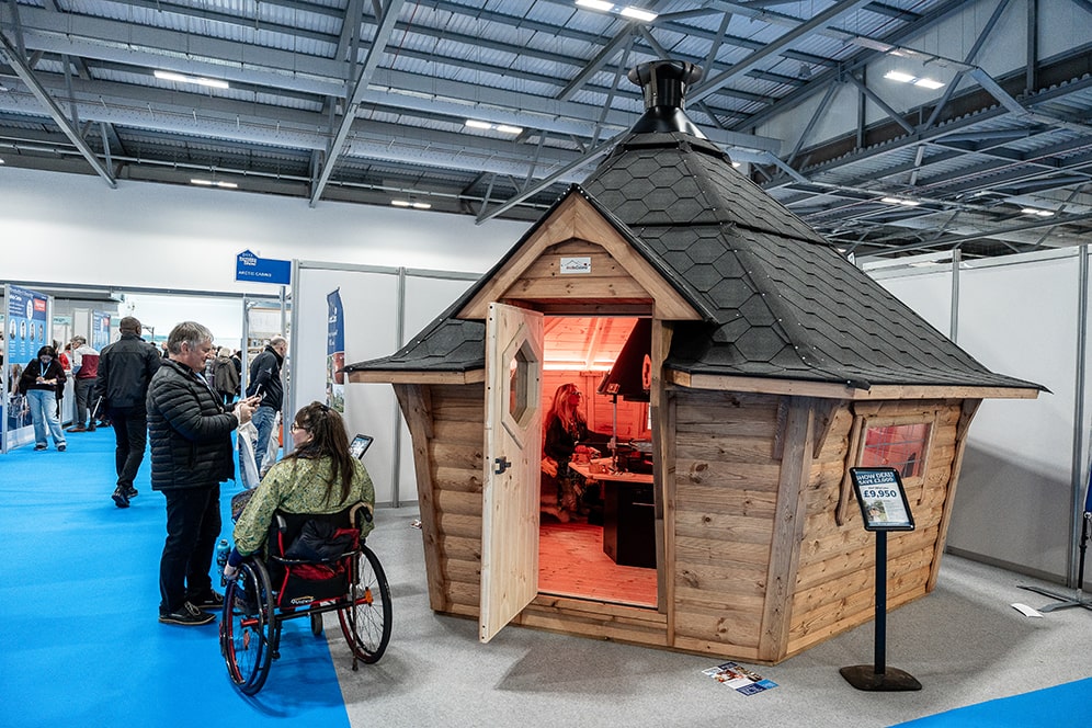Cool wooden garden hut with built-in fireplace on display