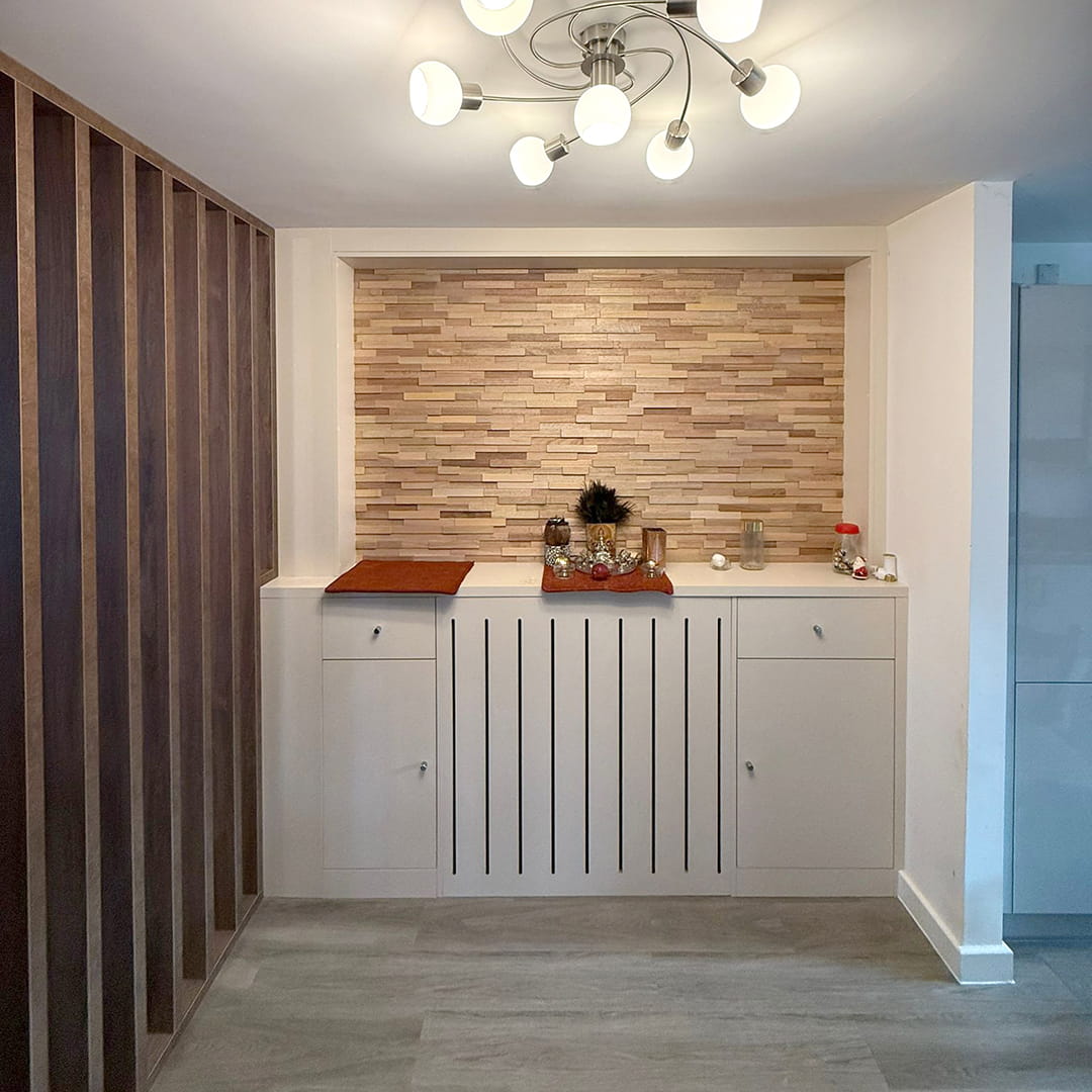 Grey fitted sideboard with slatted radiator cover and stone feature wall
