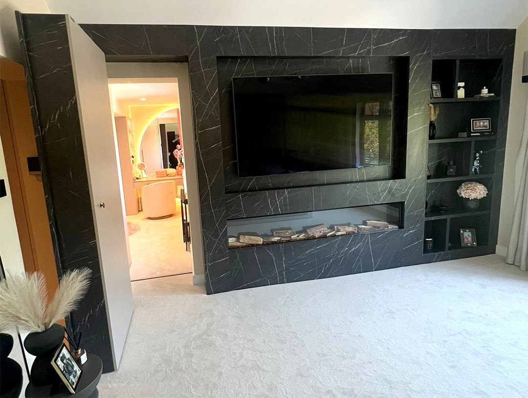 The bespoke built-in media wall installed in a home in Ascot by DAY & KNIGHT shown with its secret entrance door open