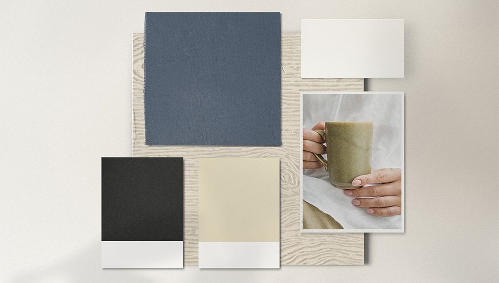 Moodboard of blue, beige and charcoal fabric swatches with green mug