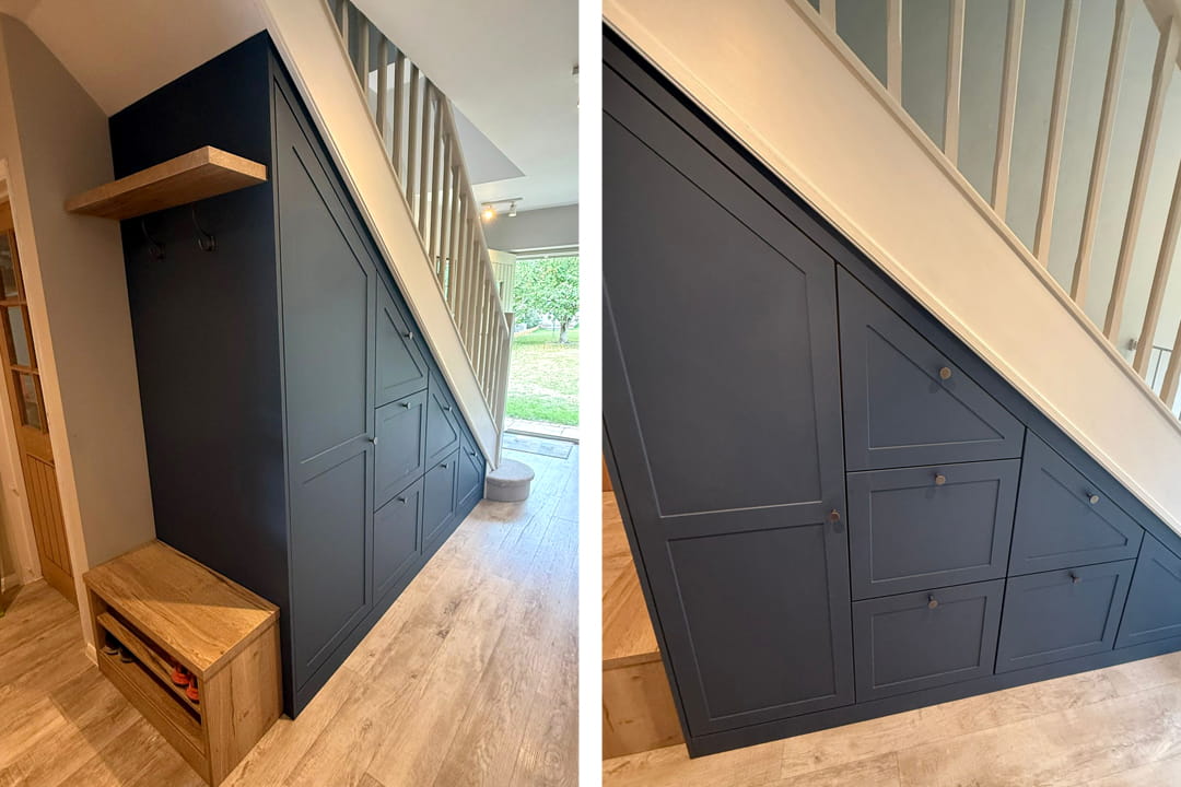Navy blue under-stairs storage with drawers, coat hooks and oak bench