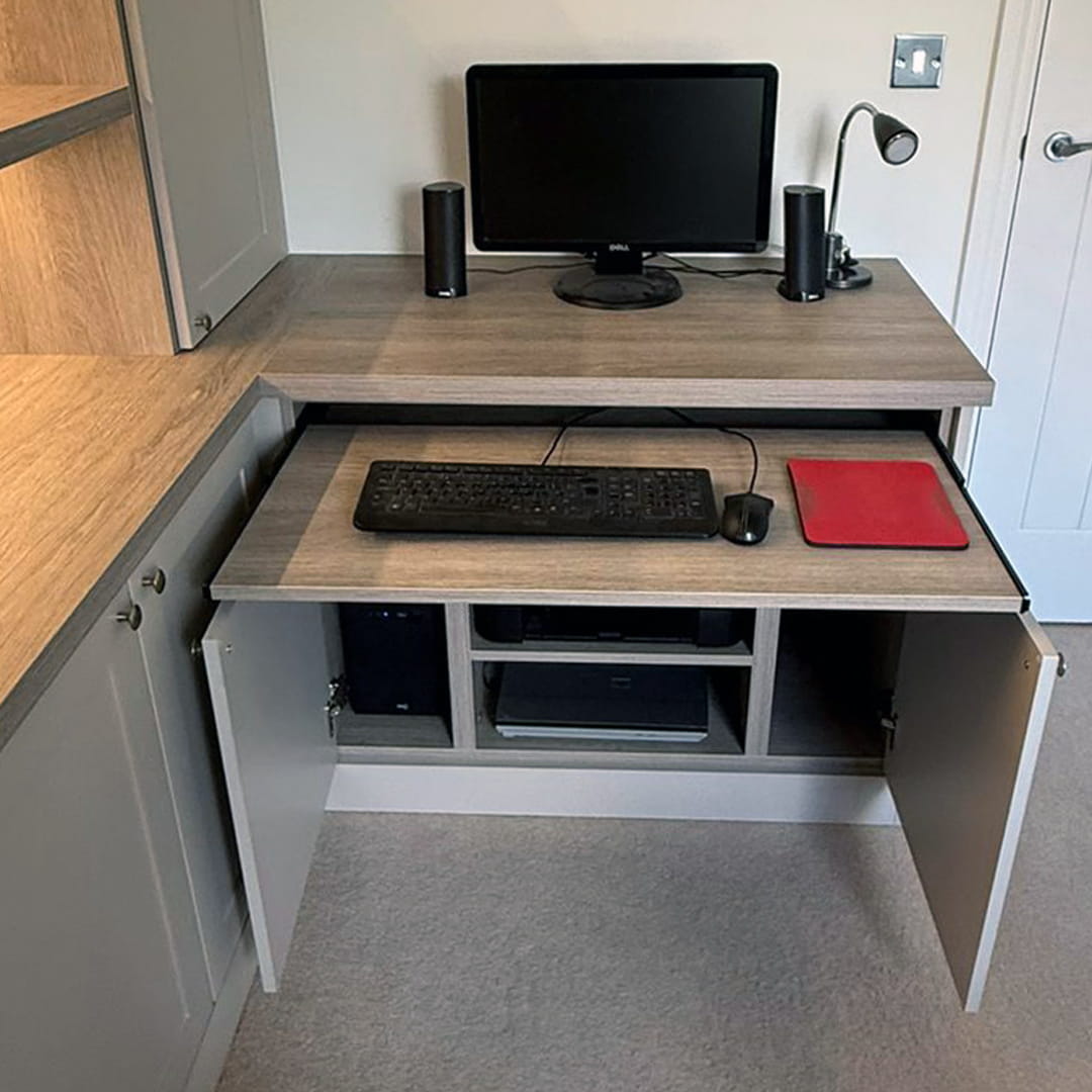 Corner desk with pull-out keyboard tray and open cabinet holding PC