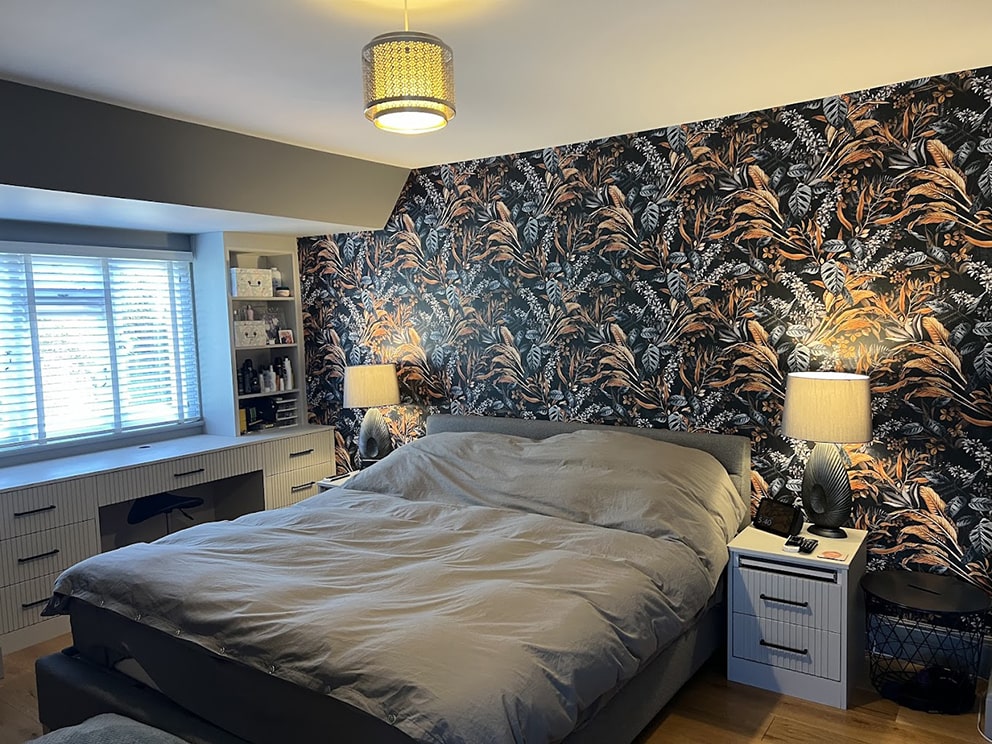 Bedroom with grey bed, bedside units and fitted vanity