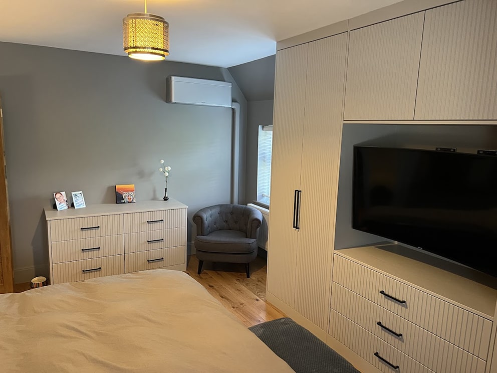 Cream fitted wardrobe with built-in TV and matching drawers