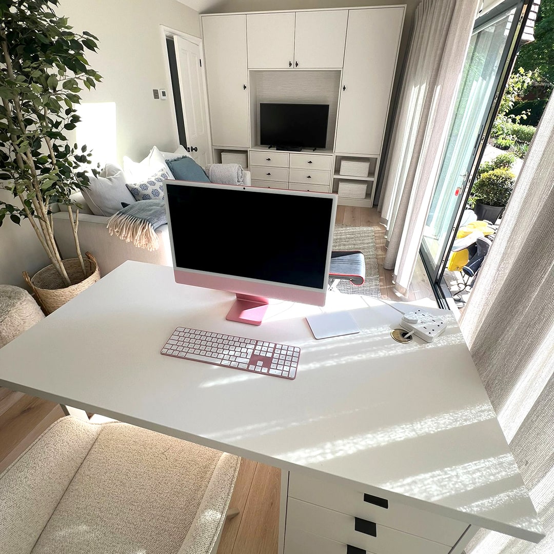 White home office desk with pink iMac and built-in storage