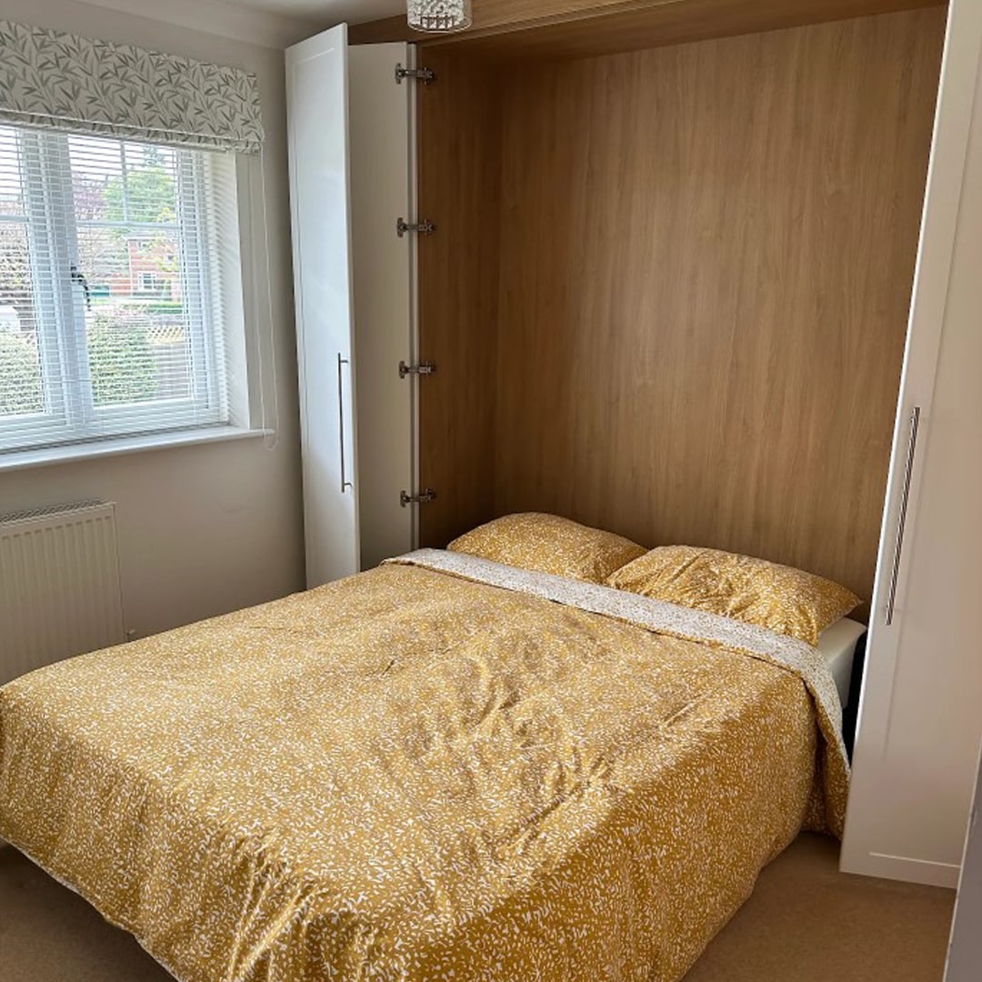 Murphy double bed folded down from oak-lined fitted wardrobe