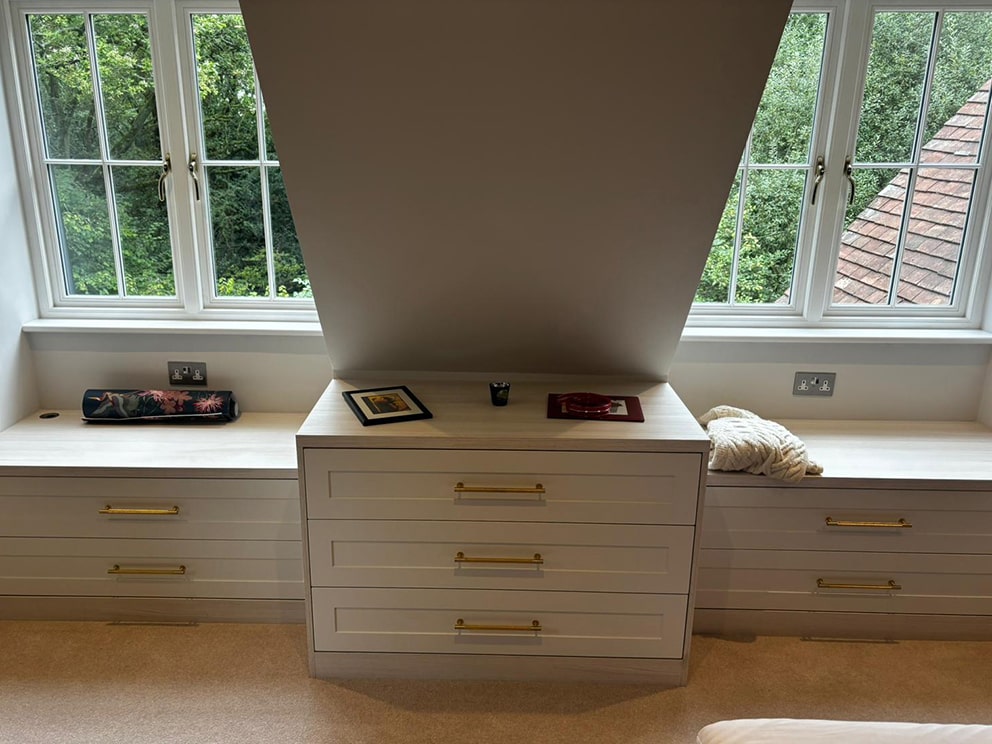 Cream drawer units built into recessed dormer windows