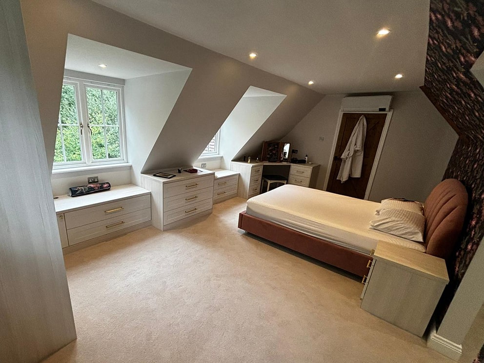 Cream shaker dormer drawer units and bed in loft bedroom